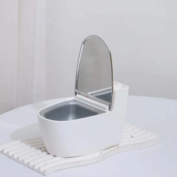 Moderne sølv-guld-hvid toilet askebæger, der ligner et miniaturetoilet, lavet af holdbart ABS-plast.