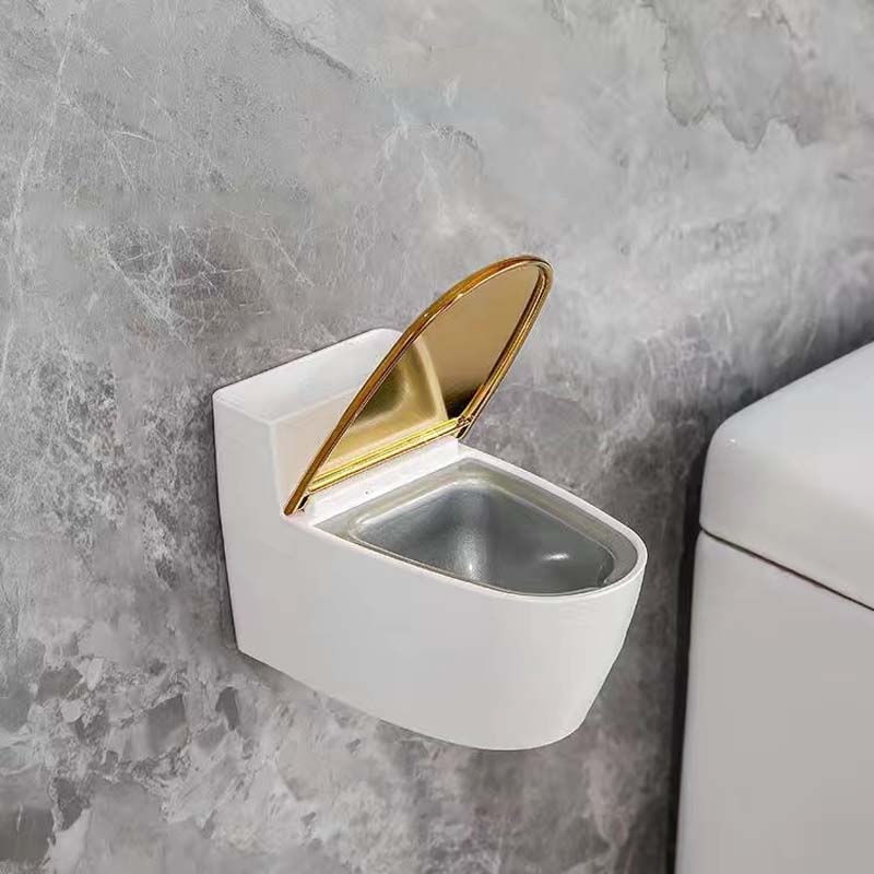 Moderne sølv-guld-hvid toilet askebæger, der ligner et miniaturetoilet, lavet af holdbart ABS-plast.