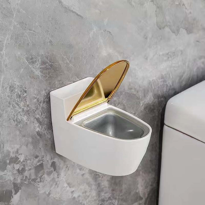 Moderne sølv-guld-hvid toilet askebæger, der ligner et miniaturetoilet, lavet af holdbart ABS-plast.