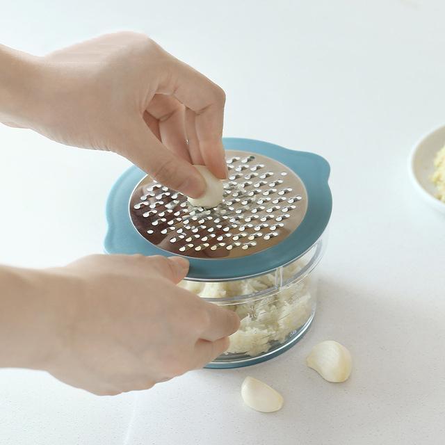 Monikäyttöinen keittiötyökalu maissille, väriltään keltainen ja sininen, joka raastaa ja viipaloi tehokkaasti.