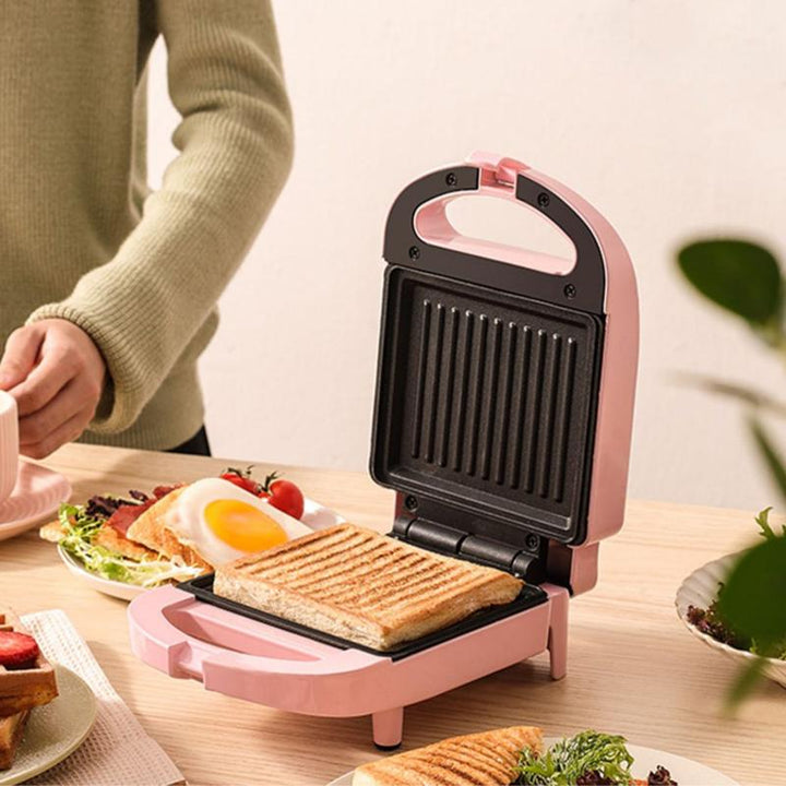 Multifarvet dobbelt smørrebrødgrill, lyserød, rød og grøn, køkkenredskab, kompakt og moderne design.