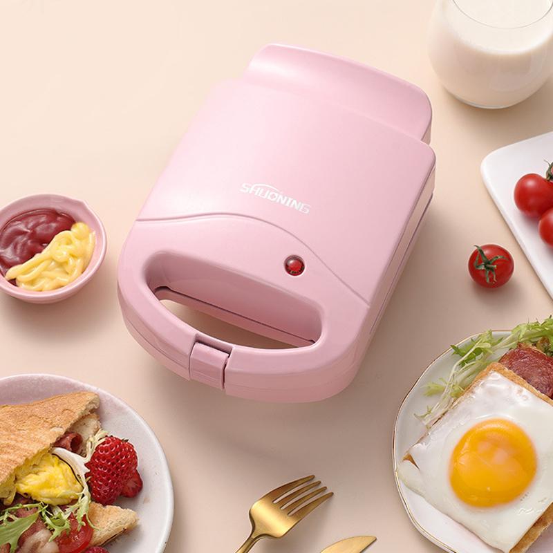 Multifarvet dobbelt smørrebrødgrill, lyserød, rød og grøn, køkkenredskab, kompakt og moderne design.