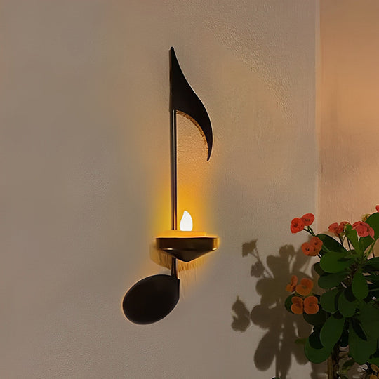 Musiikkiaiheinen musta metallinen seinävalaisin, jossa diskanttiavain ja nuottisymbolit, sopii moderniin sisustukseen ja antaa elegantin ilmeen.