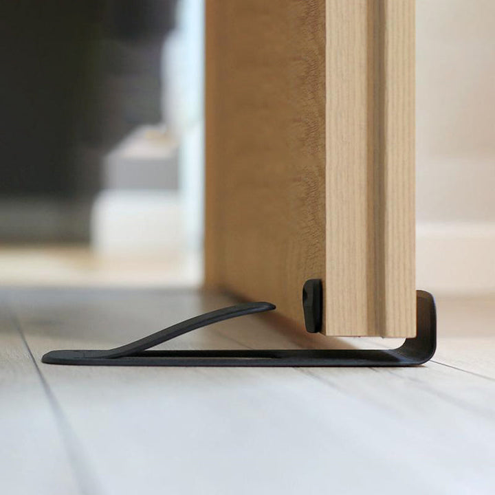 Sort dørstopper, kompakt og praktisk design, velegnet til alle overflader, øger dit hjems sikkerhed.