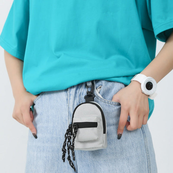 Sort unisex minirygsæk i Oxford-stof, med forlomme og lynlås, en kompakt og alsidig accessory.