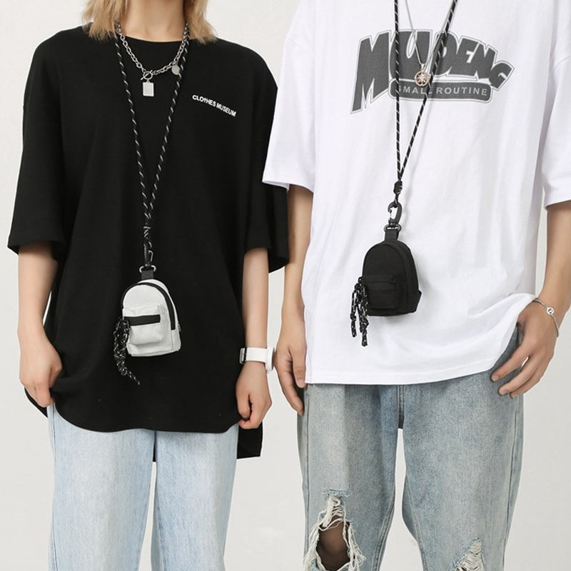 Sort unisex minirygsæk i Oxford-stof, med forlomme og lynlås, en kompakt og alsidig accessory.