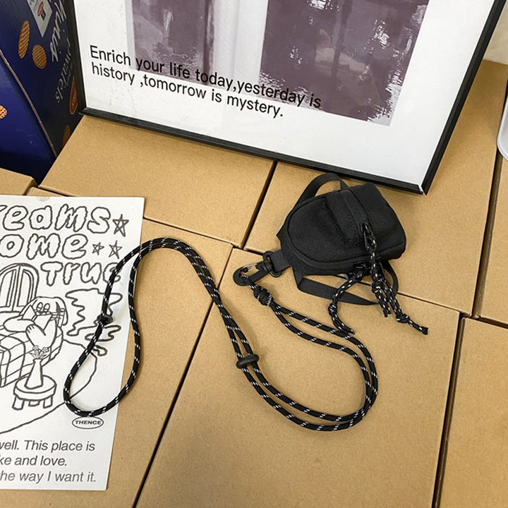 Sort unisex minirygsæk i Oxford-stof, med forlomme og lynlås, en kompakt og alsidig accessory.
