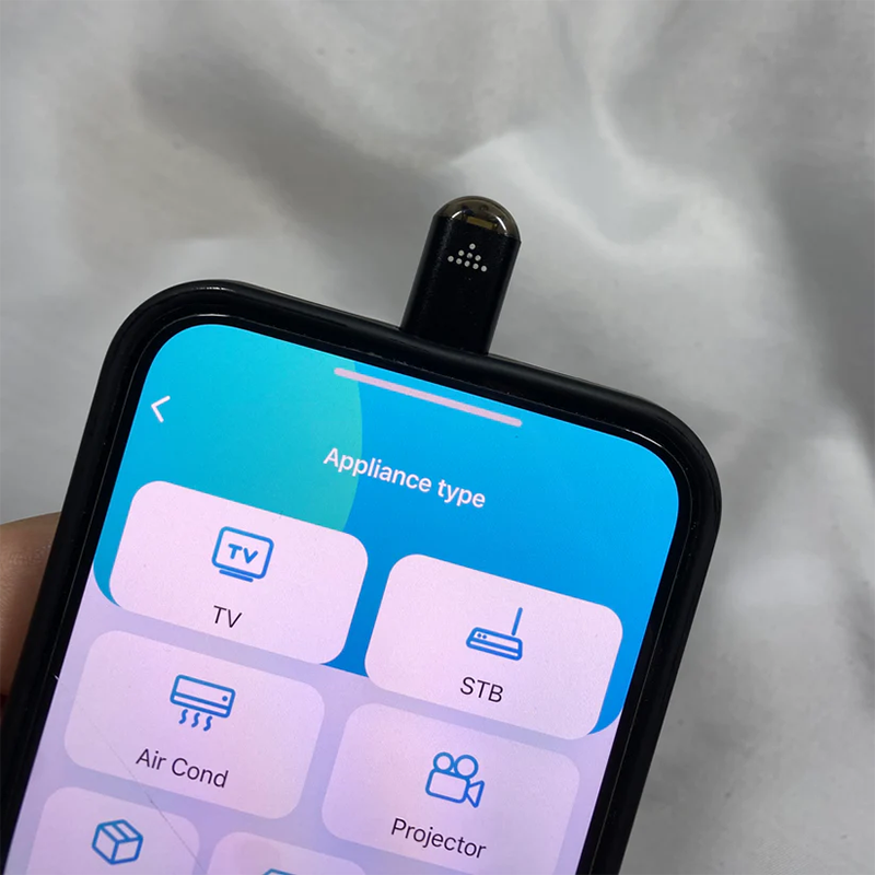 Sort multifunktionel fjernbetjening til smartphones, der styrer de fleste enheder, inklusive silikonecover og nøglering.