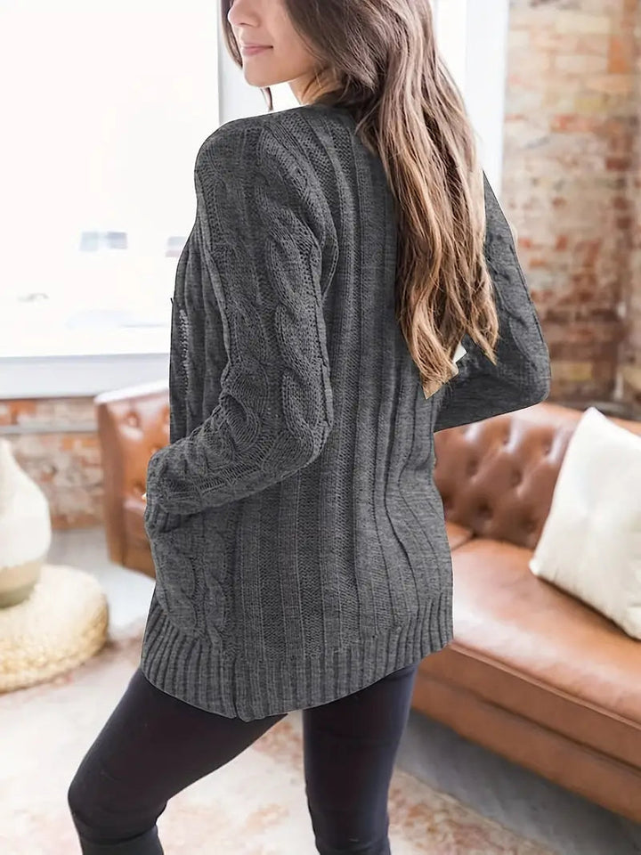 Dame kabelstrikket sweater i et blødt materiale, lange ærmer, skandinavisk minimalisme, afslappet stil.