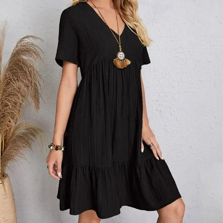Damekjole med V-hals og peplum, korte ærmer, fit and flare silhuet, let og behagelig.