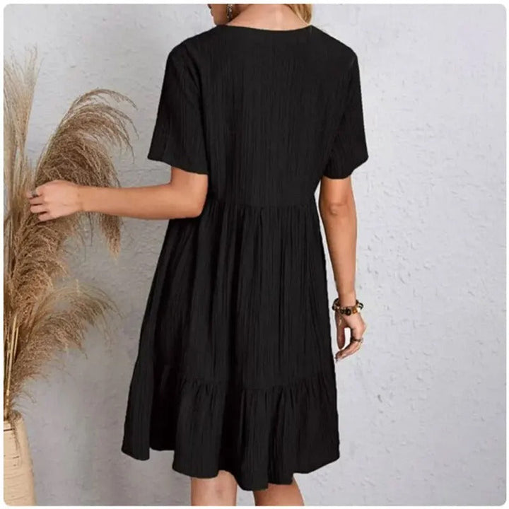 Damekjole med V-hals og peplum, korte ærmer, fit and flare silhuet, let og behagelig.