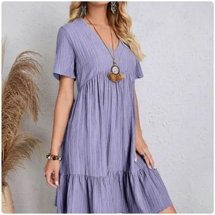 Damekjole med V-hals og peplum, korte ærmer, fit and flare silhuet, let og behagelig.
