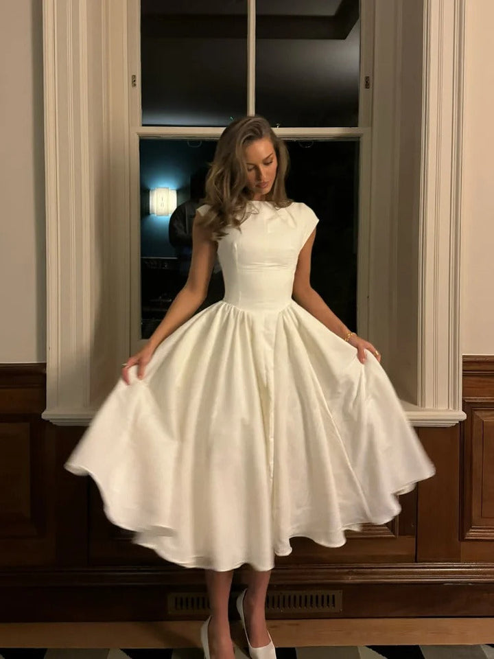 Dame elegant maxikjole med flæser og rund hals, gulvlængde og let materiale, fremhæver smukt taljen.