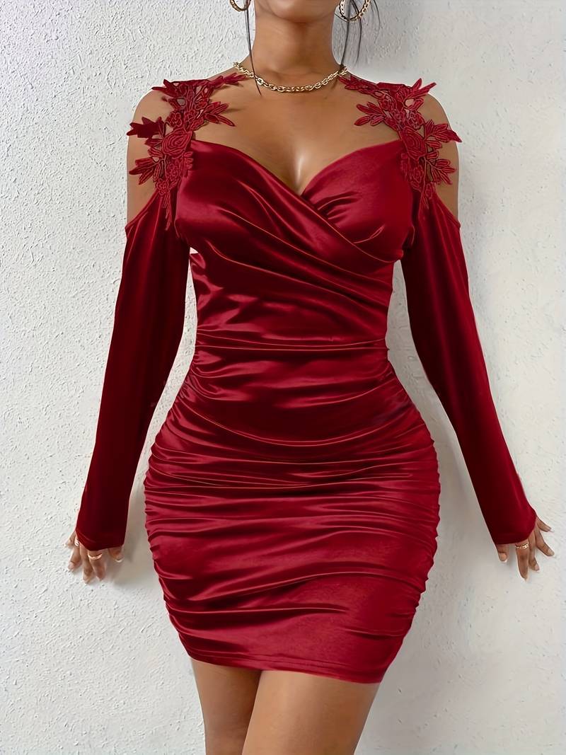Detalje af damekjole med flæser og off-shoulder design.