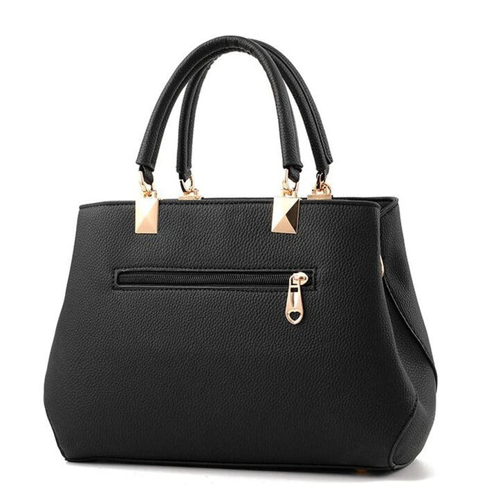 Dame skuldertaske med blomsterhåndtag, struktureret tote-stil, skinnende finish, justerbar rem.