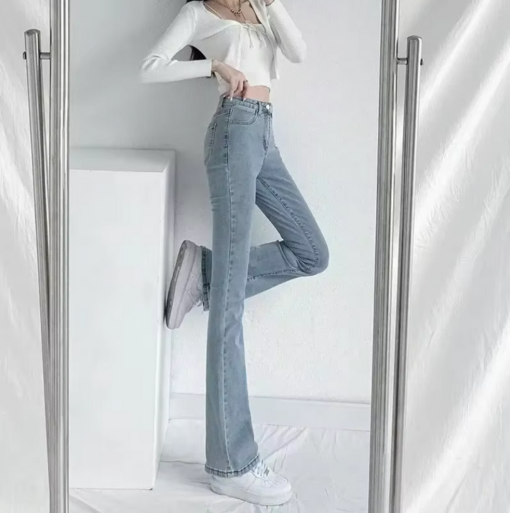 Dame højtaljede vidde jeans i blå vask, med micro-flare bukseben og en blød silhuet, detaljeret billede.