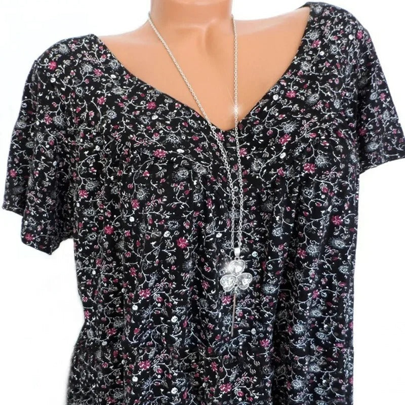 Dame blomstret V-udskåret top, blødt stof, livligt blomstermønster, sommerlig, smigrende snit, ærmeløst design.