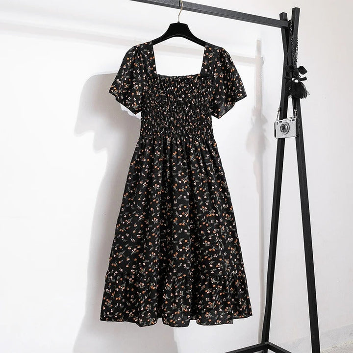 Damekjole med blomsterprint og åben ryg, regnbuens nuancer, let chiffonstof, elastisk talje.
