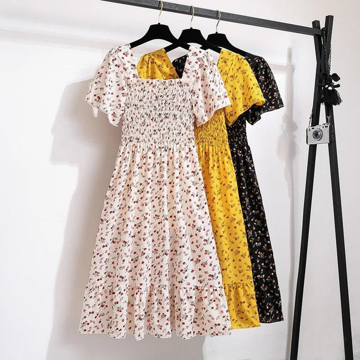 Damekjole med blomsterprint og åben ryg, regnbuens nuancer, let chiffonstof, elastisk talje.