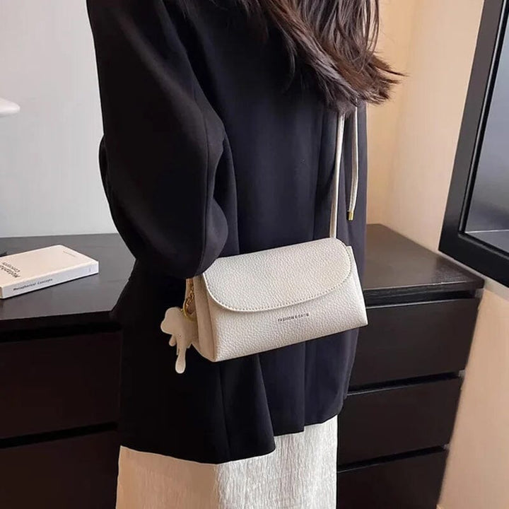 Lähempi kuva naisten crossbody laukusta, musta, norsuriipus.