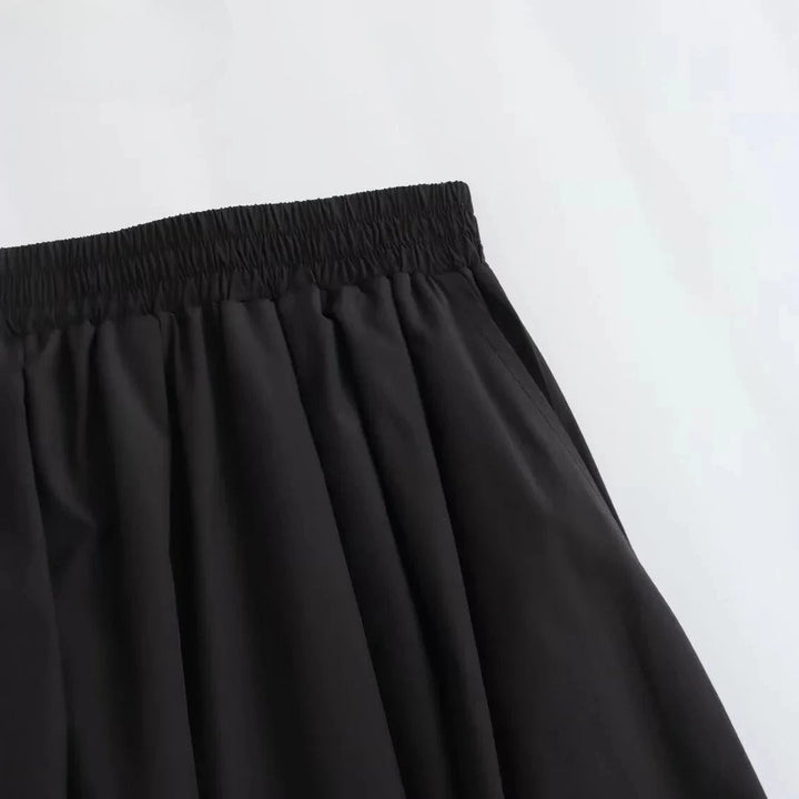 Dame sort plisseret A-line nederdel, højtaljet, skaber en strømlinet og elegant silhuet.
