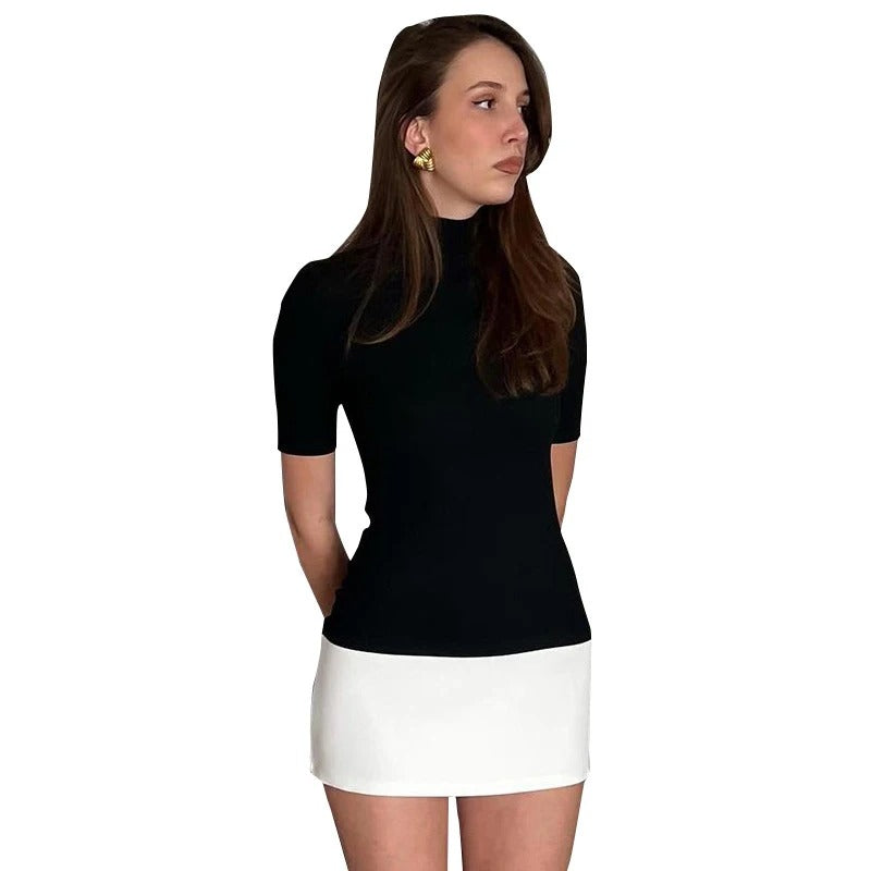 Dame sort-hvid patchwork bodycon kjole, turtleneck krave, halvlange ærmer, moderne og elegant look.