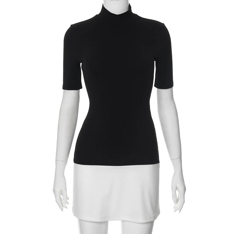 Dame sort-hvid patchwork bodycon kjole, turtleneck krave, halvlange ærmer, moderne og elegant look.
