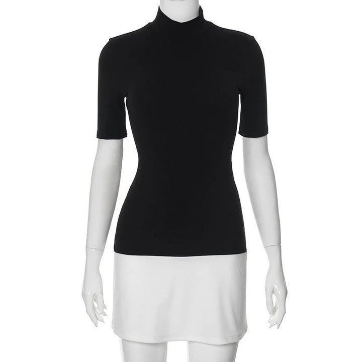 Dame sort-hvid patchwork bodycon kjole, turtleneck krave, halvlange ærmer, moderne og elegant look.