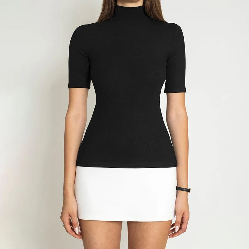 Dame sort-hvid patchwork bodycon kjole, turtleneck krave, halvlange ærmer, moderne og elegant look.