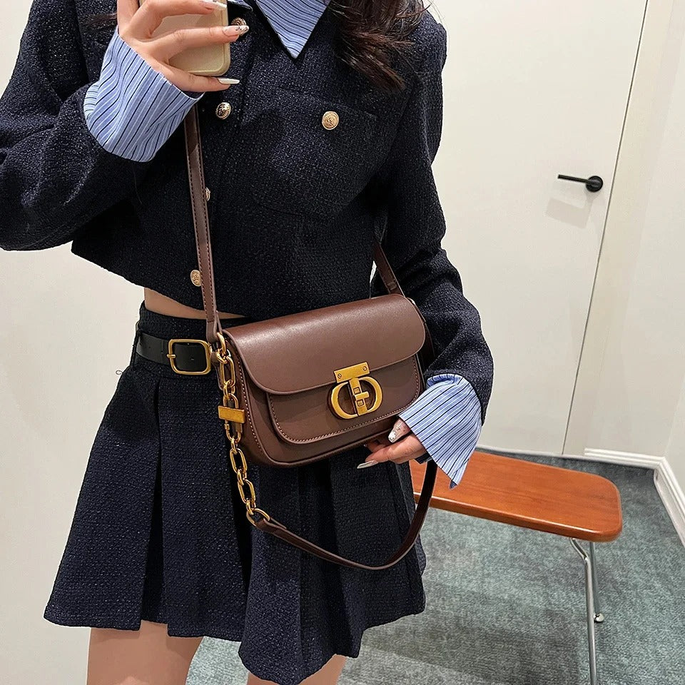 Dame crossbody taske, sort og brun, minimalistisk design, justerbar rem, kompakt størrelse.