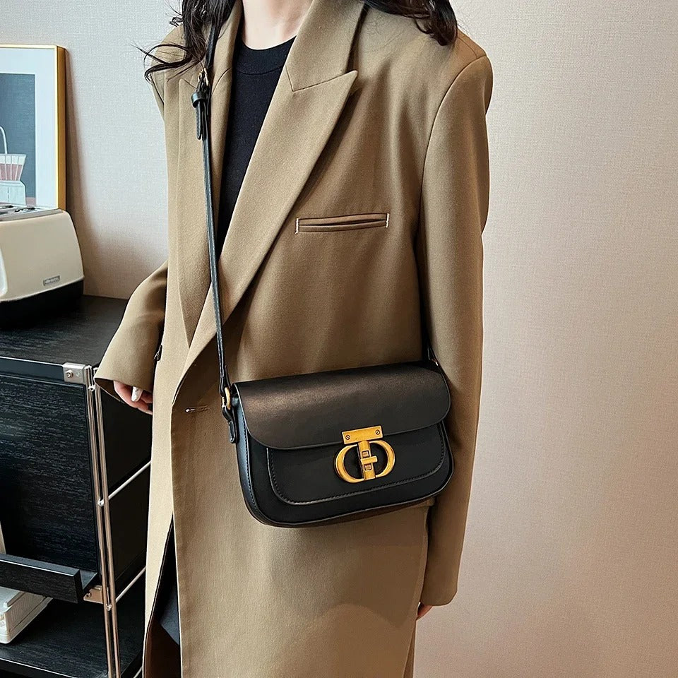 Dame crossbody taske, sort og brun, minimalistisk design, justerbar rem, kompakt størrelse.