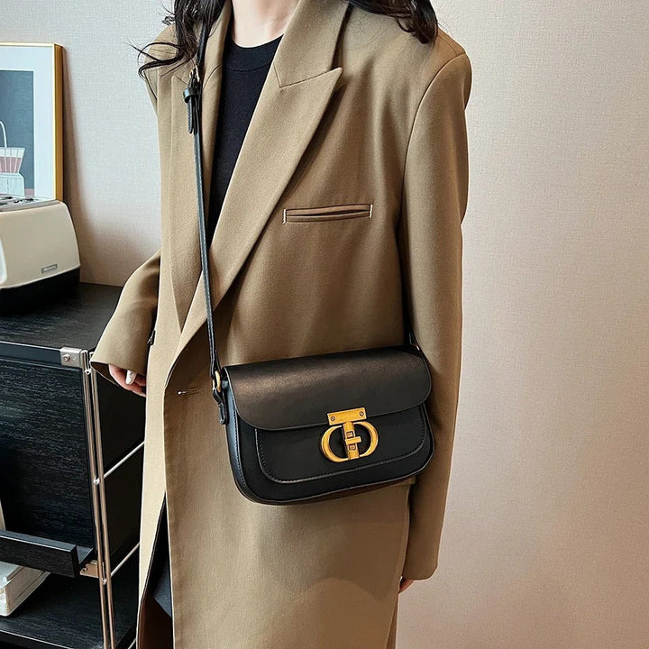 Dame crossbody taske, sort og brun, minimalistisk design, justerbar rem, kompakt størrelse.