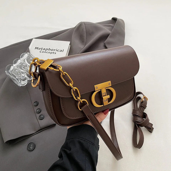 Dame crossbody taske, sort og brun, minimalistisk design, justerbar rem, kompakt størrelse.