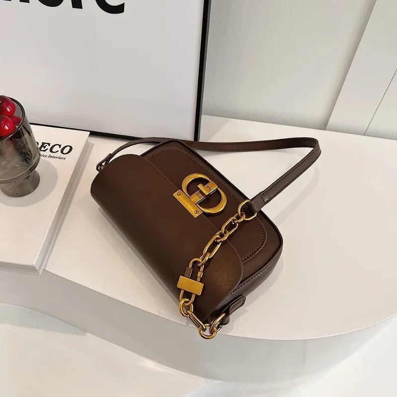 Dame crossbody taske, sort og brun, minimalistisk design, justerbar rem, kompakt størrelse.