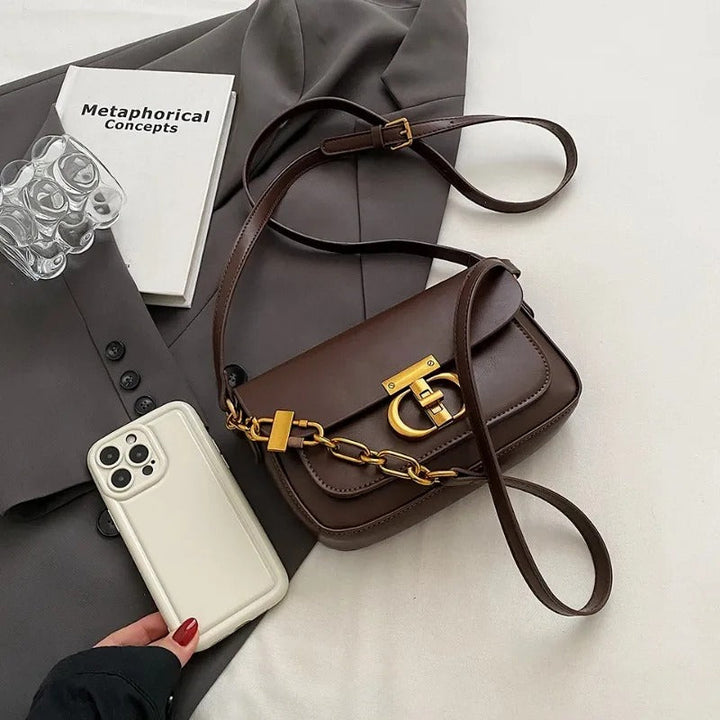Dame crossbody taske, sort og brun, minimalistisk design, justerbar rem, kompakt størrelse.