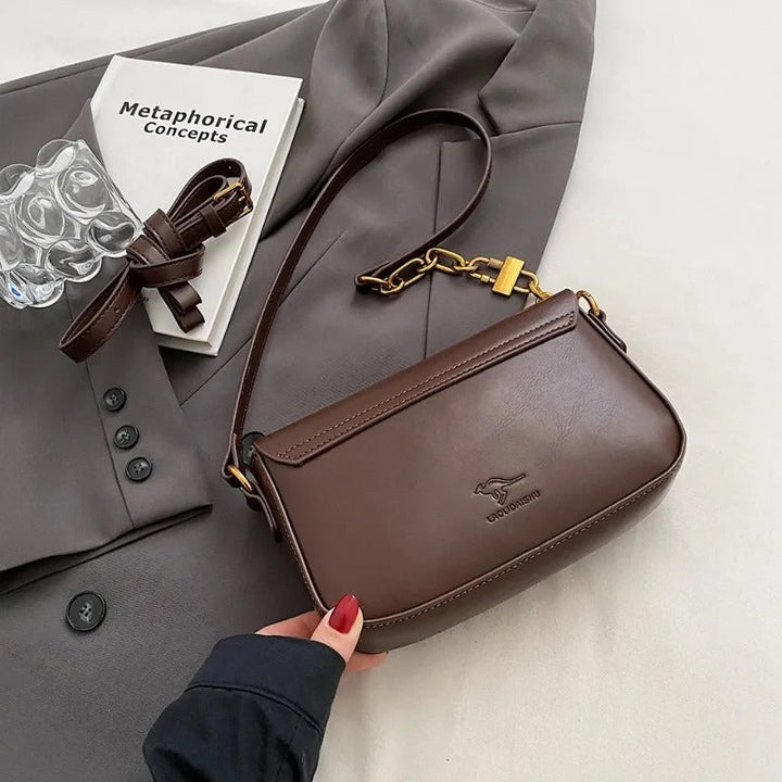 Dame crossbody taske, sort og brun, minimalistisk design, justerbar rem, kompakt størrelse.