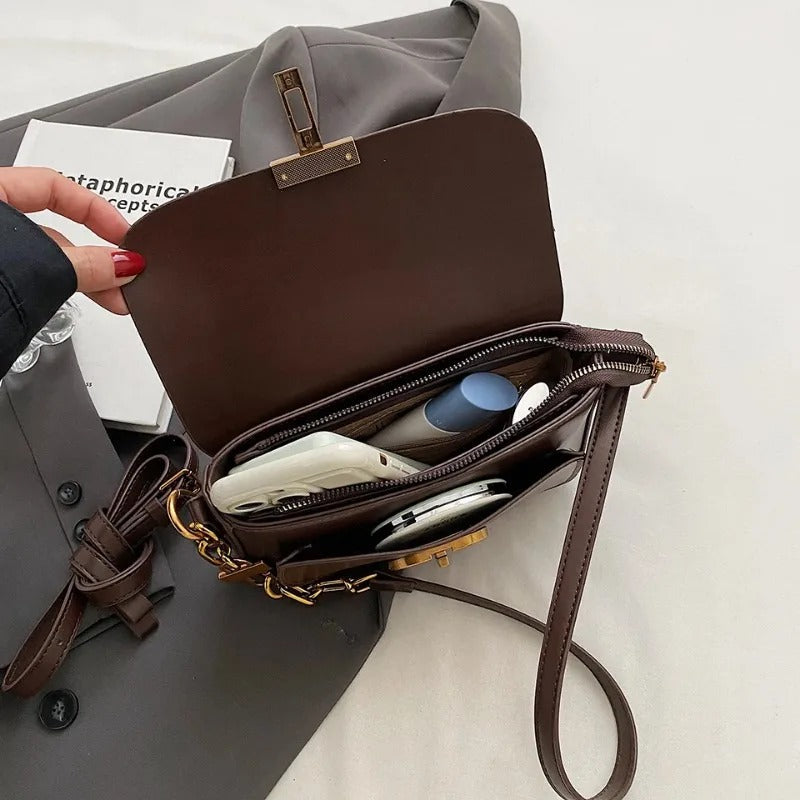 Dame crossbody taske, sort og brun, minimalistisk design, justerbar rem, kompakt størrelse.