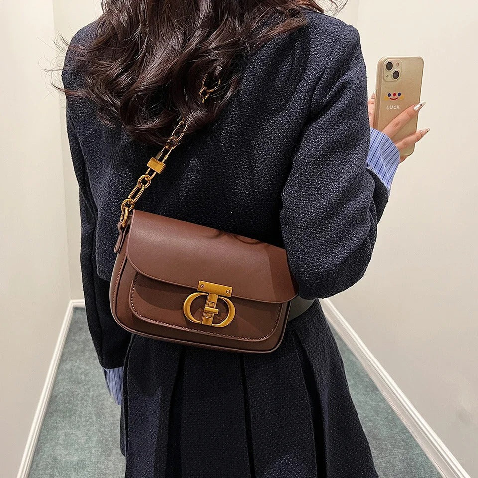 Dame crossbody taske, sort og brun, minimalistisk design, justerbar rem, kompakt størrelse.