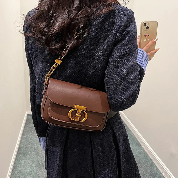 Dame crossbody taske, sort og brun, minimalistisk design, justerbar rem, kompakt størrelse.