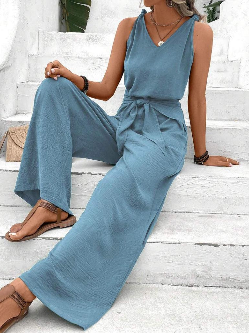 Dame blå vidt ben jumpsuit med V-hals, ærmeløs og let stof, perfekt til sommer.