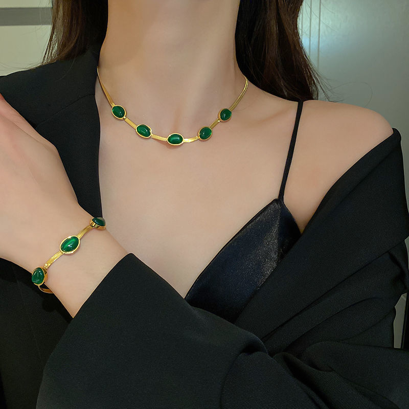 Dame smaragd smykkesæt, grøn nuance, titaniumstål, elegant smykkesæt, delikat kæde, charmerende accessory.