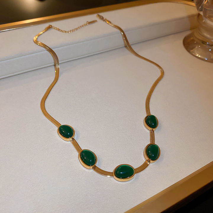 Dame smaragd smykkesæt, grøn nuance, titaniumstål, elegant smykkesæt, delikat kæde, charmerende accessory.