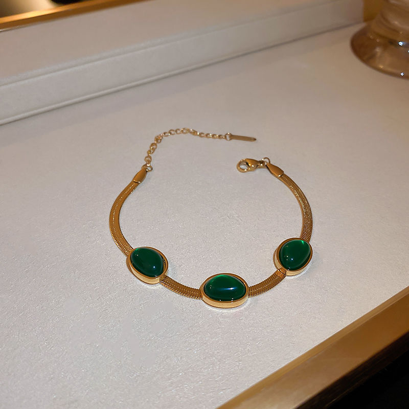 Dame smaragd smykkesæt, grøn nuance, titaniumstål, elegant smykkesæt, delikat kæde, charmerende accessory.