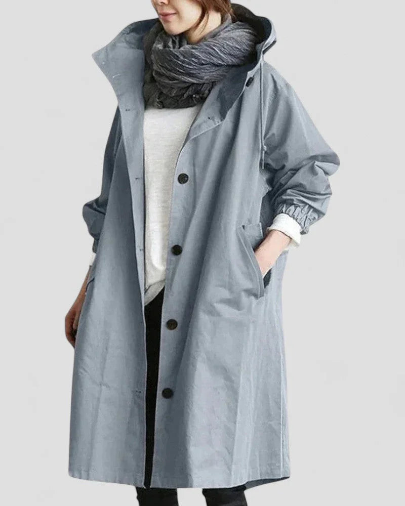 "Naisten tyylikäs hupullinen kevättakki, pitkänmallinen siluetti, urbaani design, vedenpitävä, nappisuljenta edessä."