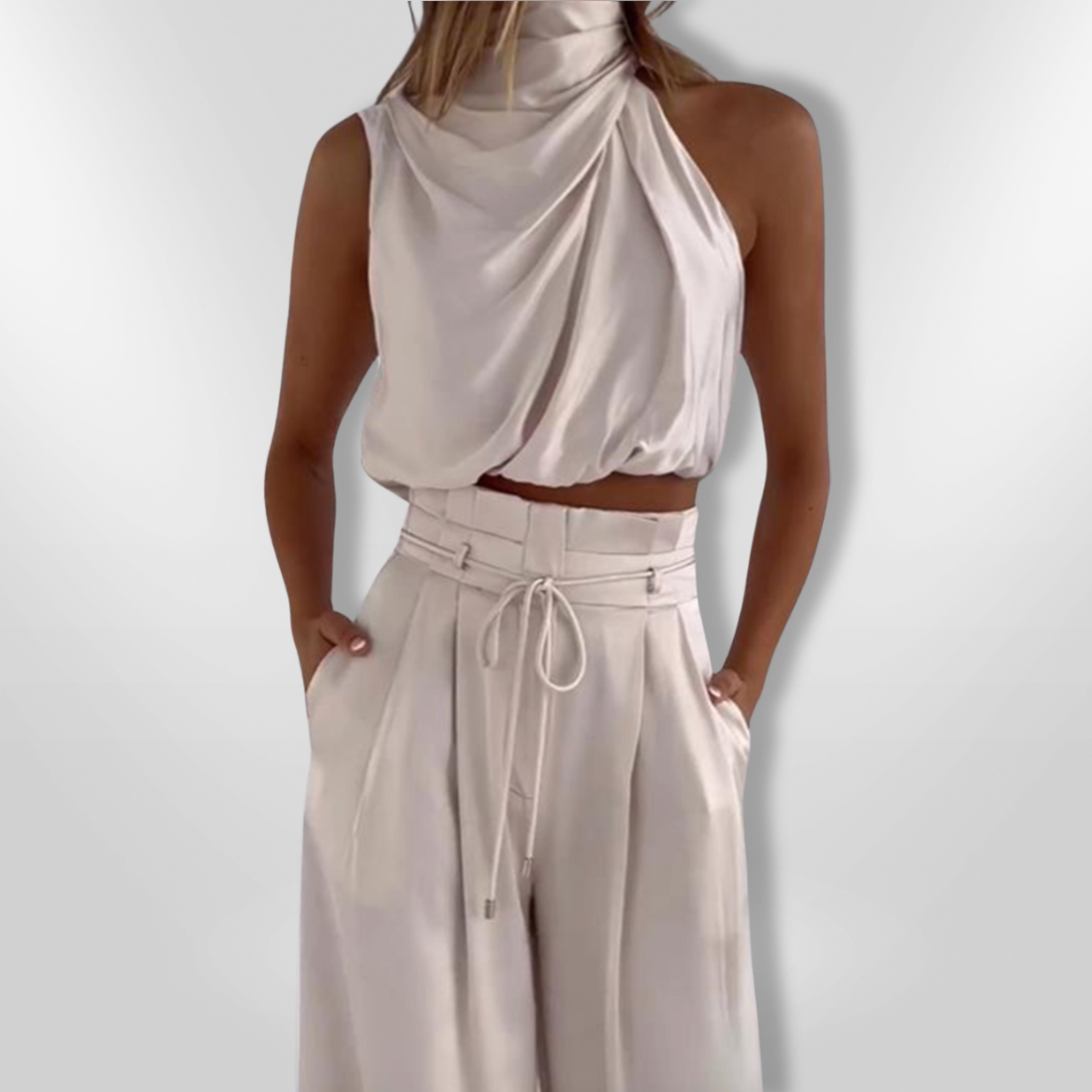Dame stilfuldt to-delt sæt: højhalset top og brede bukser, et klassisk look i moderne mode.