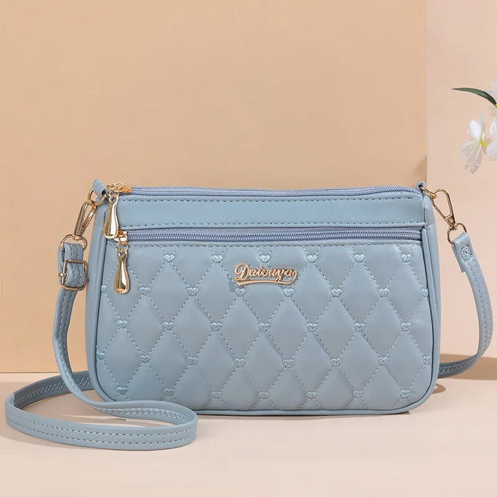 Dame elegant broderet crossbody taske, kompakt størrelse, subtil broderi, justerbar skulderrem.