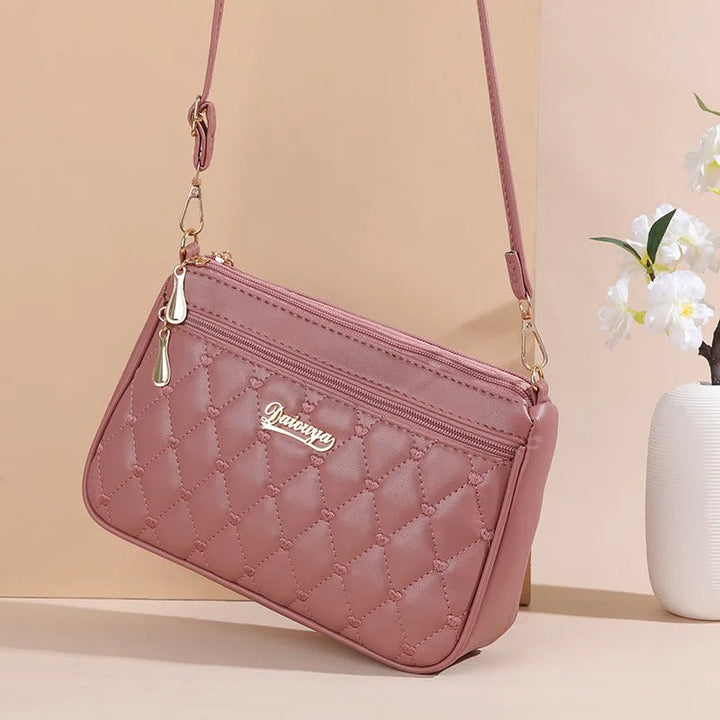 Dame elegant broderet crossbody taske, kompakt størrelse, subtil broderi, justerbar skulderrem.