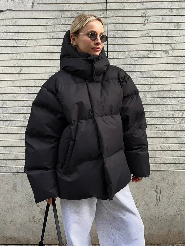 Dame oversized polstret vinterjakke, tyk isolering, stor hætte, praktiske lommer, lysegrå farve.