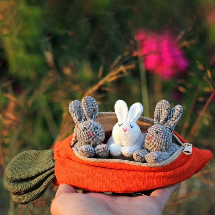 Sød orange gulerodstaske med tre harer, et forårs-accessory til påsken. Bomuldstaske fotograferet forfra.