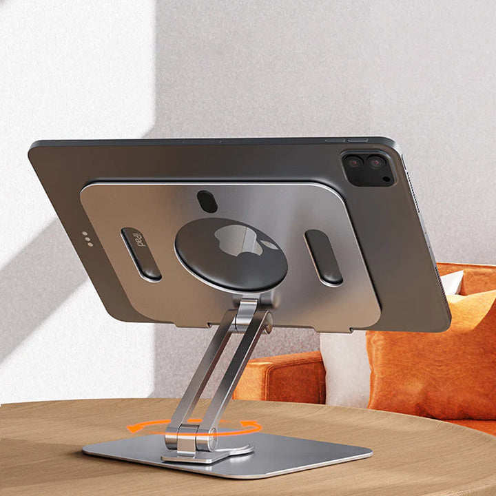 Sammenklappelig og drejelig iPad-holder i aluminium, grå, præsenteret på et bord, 360° justerbarhed, ergonomisk design og holdbar.